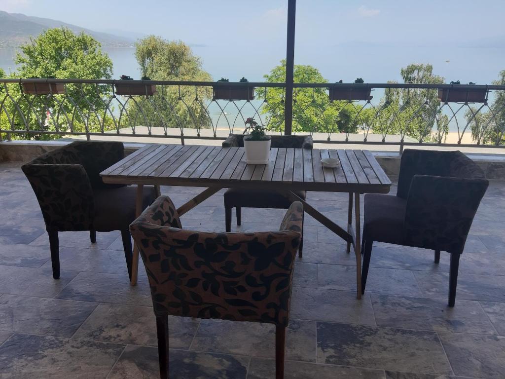 uma mesa de madeira e cadeiras num pátio em Nice apartment with terrace and like view . em Pogradec