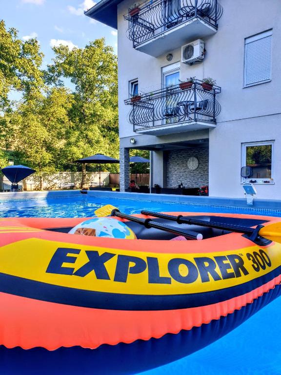 a pool with an inflatable paddle boat in front of a building at Vila Katarina in Vrnjačka Banja