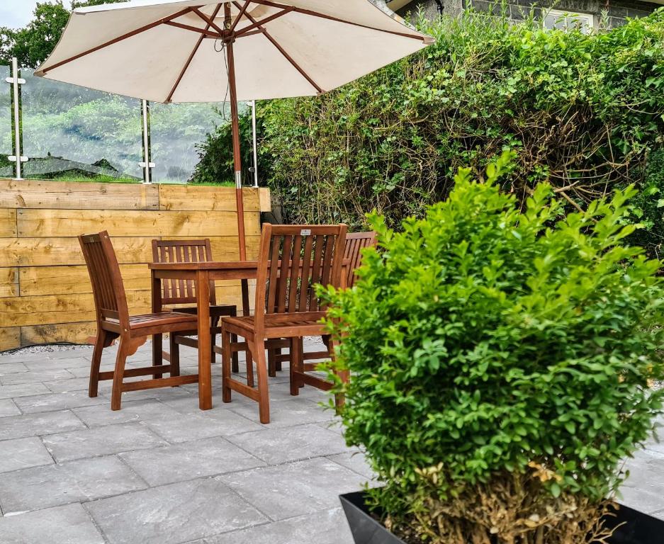 a table and two chairs and an umbrella on a patio at Ty Morgan's Apartments in Rhayader