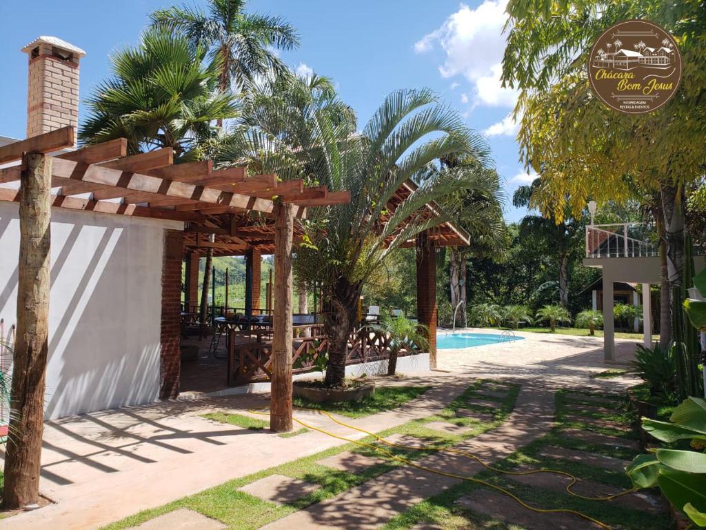 a resort with a swimming pool and a wooden pergola at Chácara Bom Jesus in Caconde