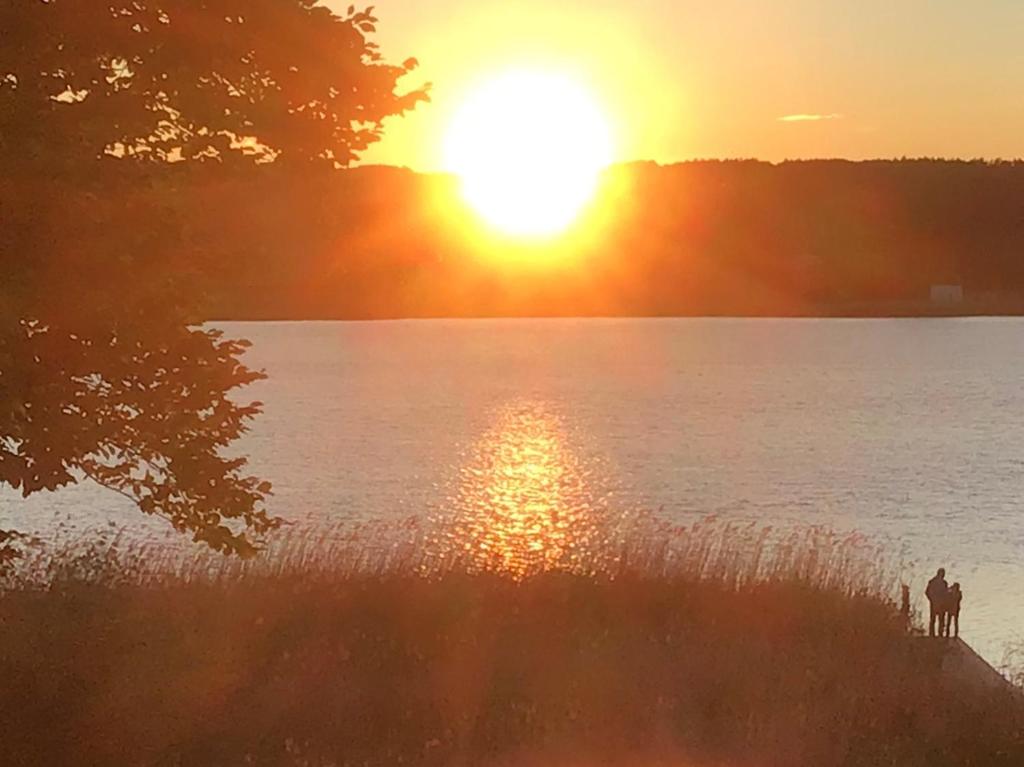 オストゼーバート・ゼリンにあるZeesenhaus 5 mit Seeblickの二人乗馬の乗る湖上の夕日