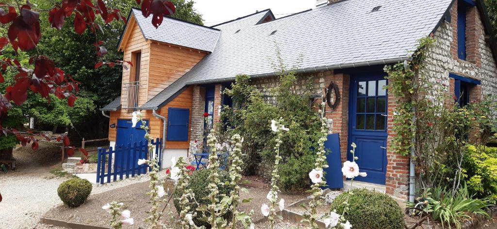 une maison ancienne avec des portes bleues et des fleurs dans l'établissement Le Four À Pain, à Sahurs