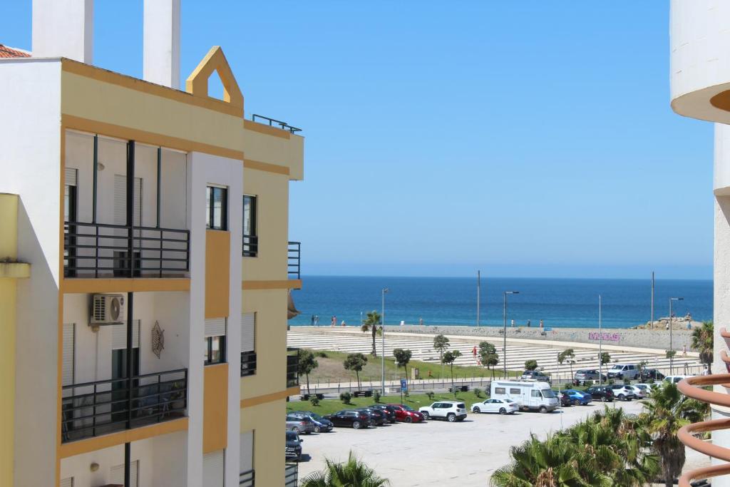 uma vista para a praia a partir da varanda de um edifício em Caparica Sunny House II em Costa da Caparica
