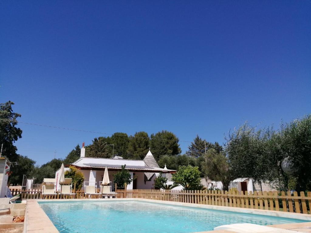 a swimming pool with a fence and a house at Villa Franchino in Ostuni