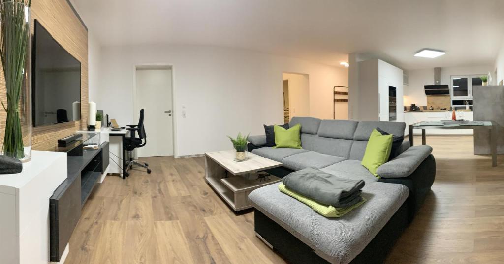 a living room with a gray couch and a tv at Firmen & Ferienwohnung Brecht 1 in Waibstadt