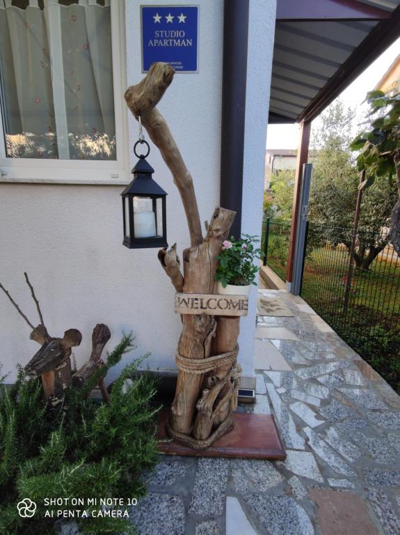 a tree stump statue in front of a house at Susy in Umag