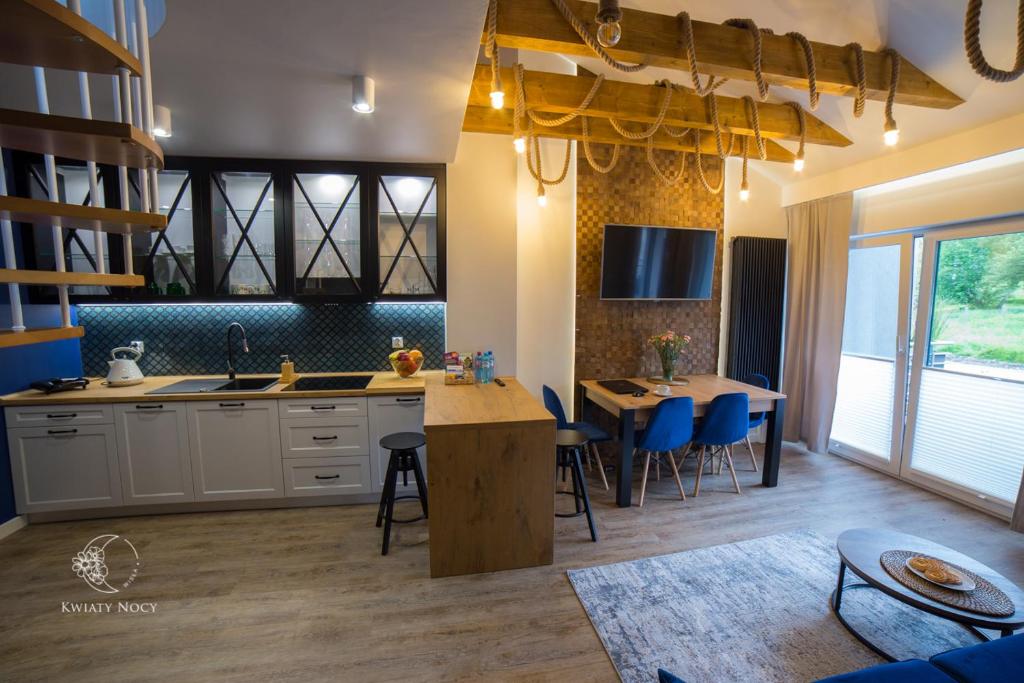 Apartamenty "Kwiaty Nocy" i "W Krainie Mchu" - Wisła في فيسلا: مطبخ وكراسي زرقاء وطاولة فيه