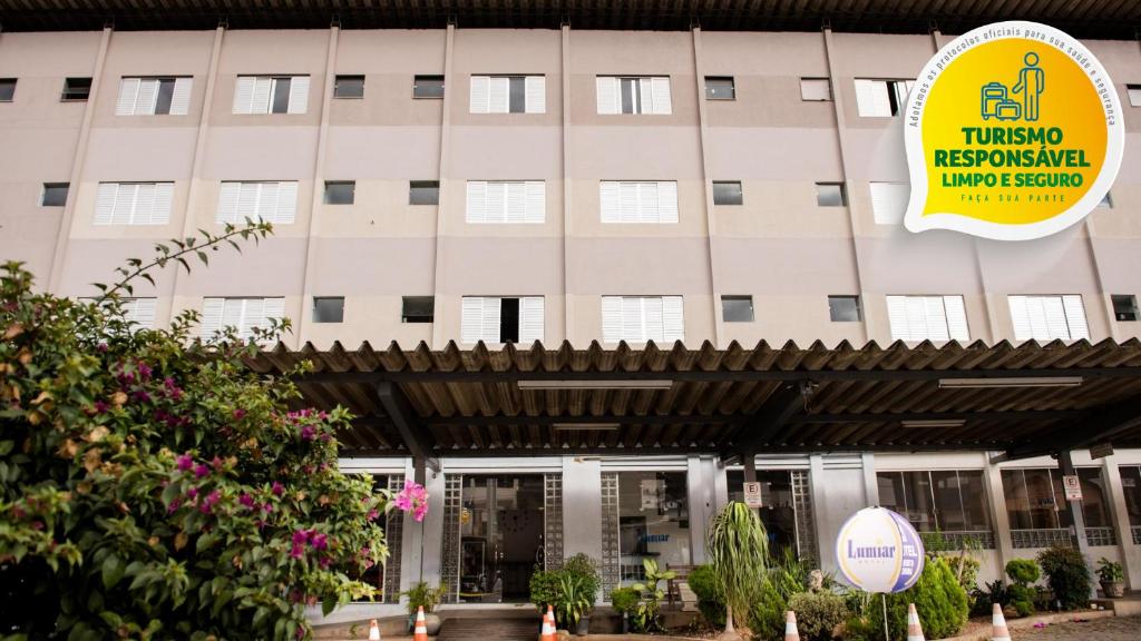 een gebouw met een bord ervoor bij Hotel Lumiar in Coronel Fabriciano
