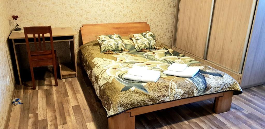 1 dormitorio con 1 cama con mesa y silla en Vasaros apartamentas Nr3 en Palanga