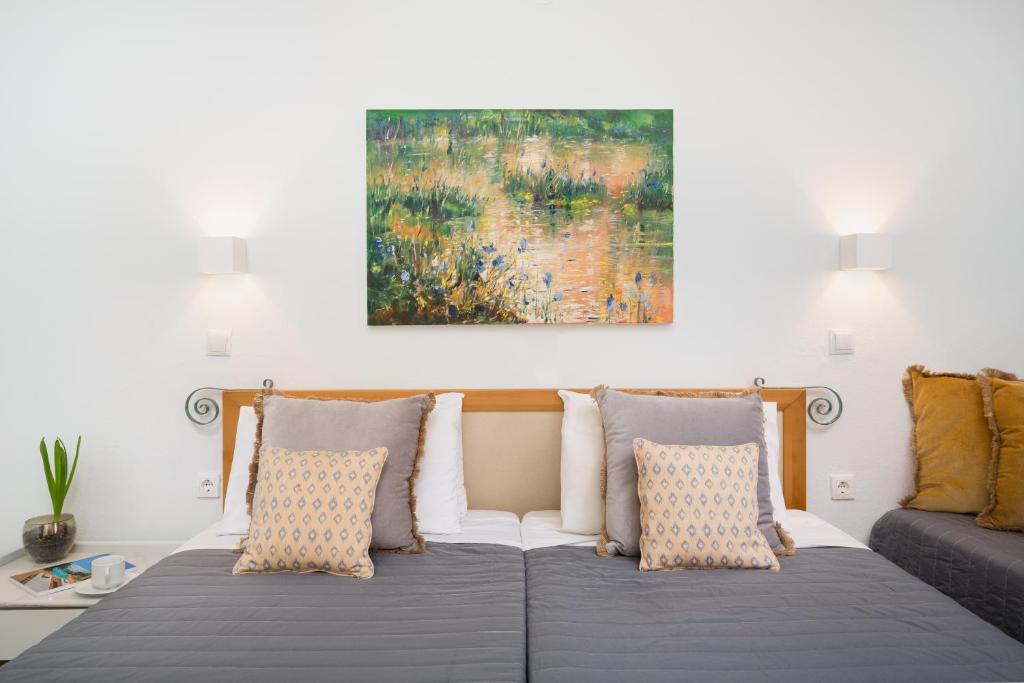a bed with pillows and a painting on the wall at Finata Studios in Kavos