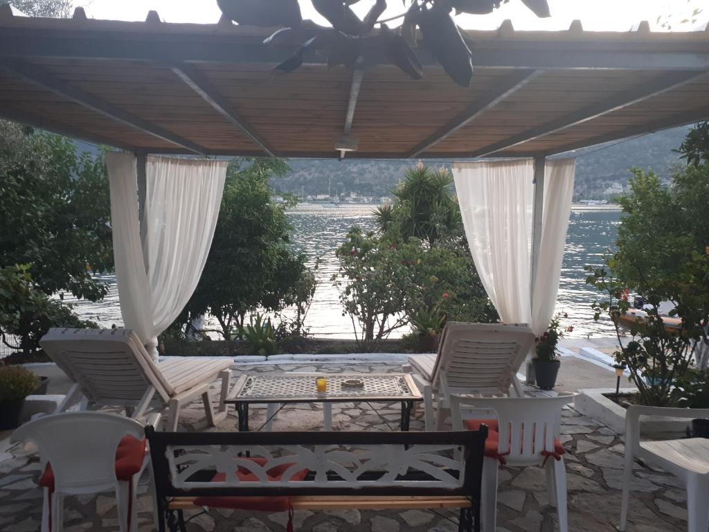 a patio with chairs and a table with a view of the water at Geni Bay in Yenion