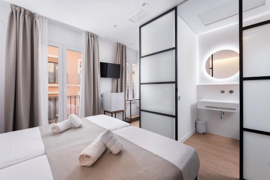 a bedroom with two white towels on a bed at VIL5 by Be Alicante in Alicante