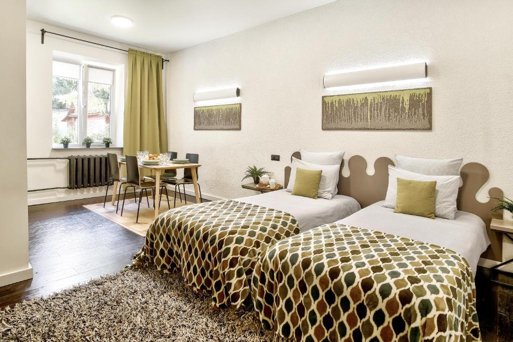 a hotel room with two beds and a table at Nice Euapartments in the center in Grodno