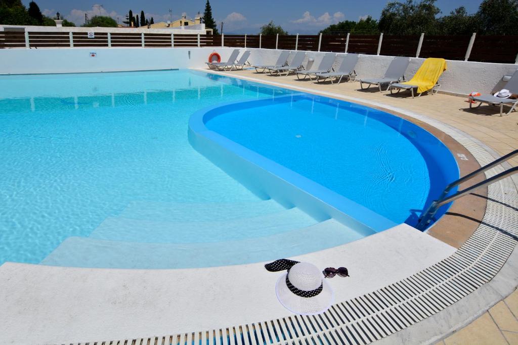 una piscina con sombrero y sillas en Alex Apartment Suites en Virós