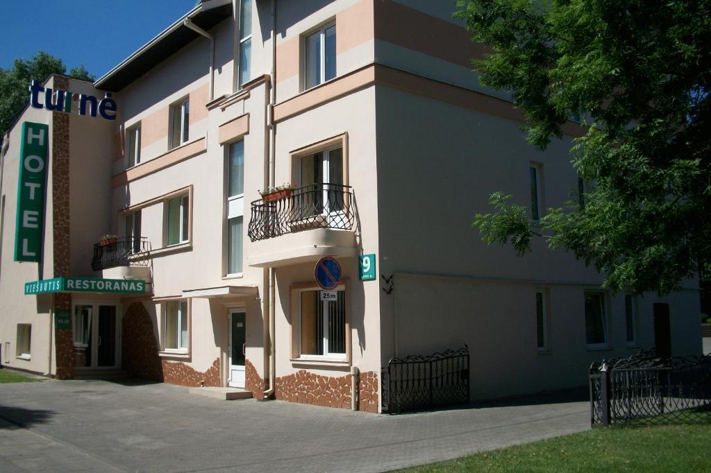 - un grand bâtiment blanc avec un balcon dans l'établissement Turnė, à Šiauliai