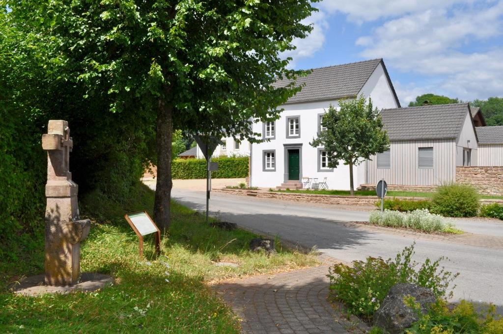 une rue avec une maison blanche et un arbre dans l'établissement Ferienhaus Baustert, à Baustert