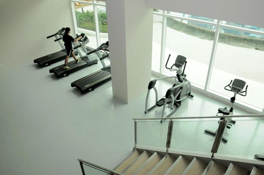 a woman running on a treadmill in a gym at Affordable Makati Serviced Apartments in Manila