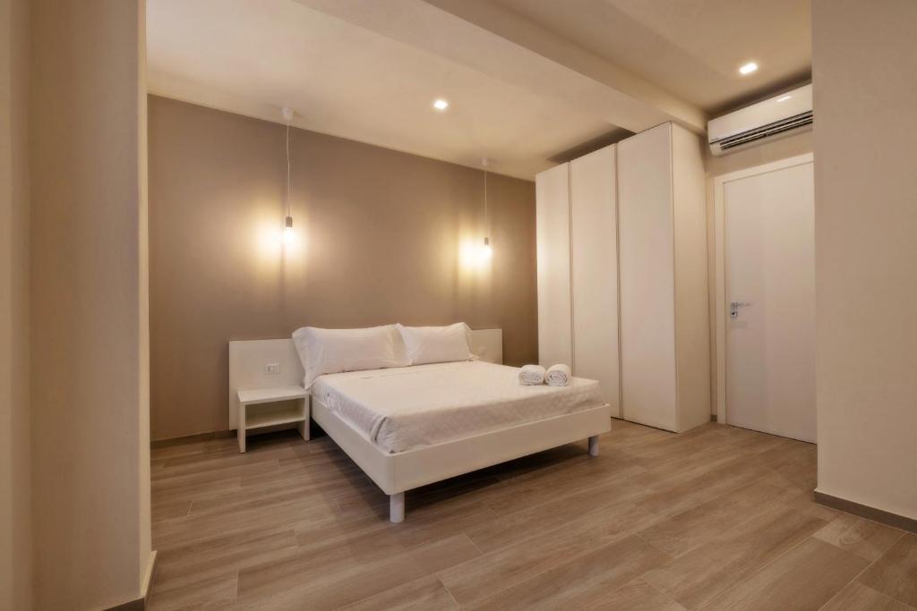 una camera con letto bianco di Aria di Mare Apartments a Trapani