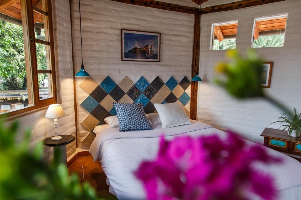 a bedroom with a bed with purple flowers at Rukka Lodge in Tumbaco