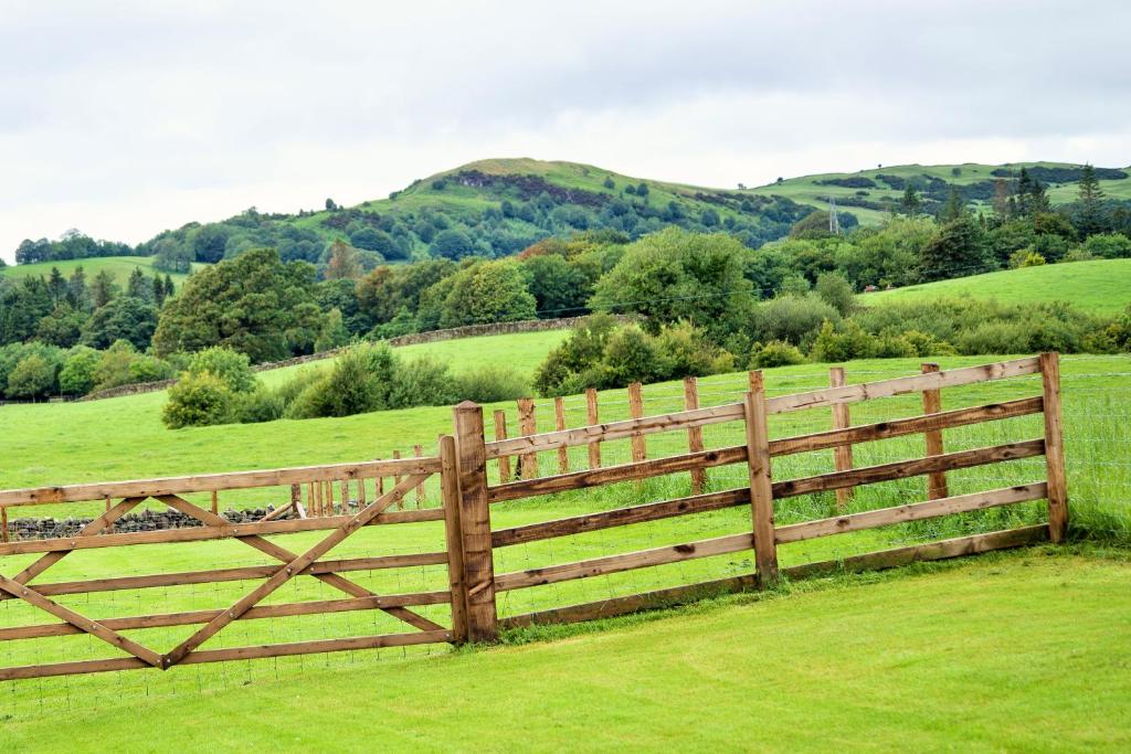 una recinzione di legno in mezzo a un campo di The Orchards a Kendal