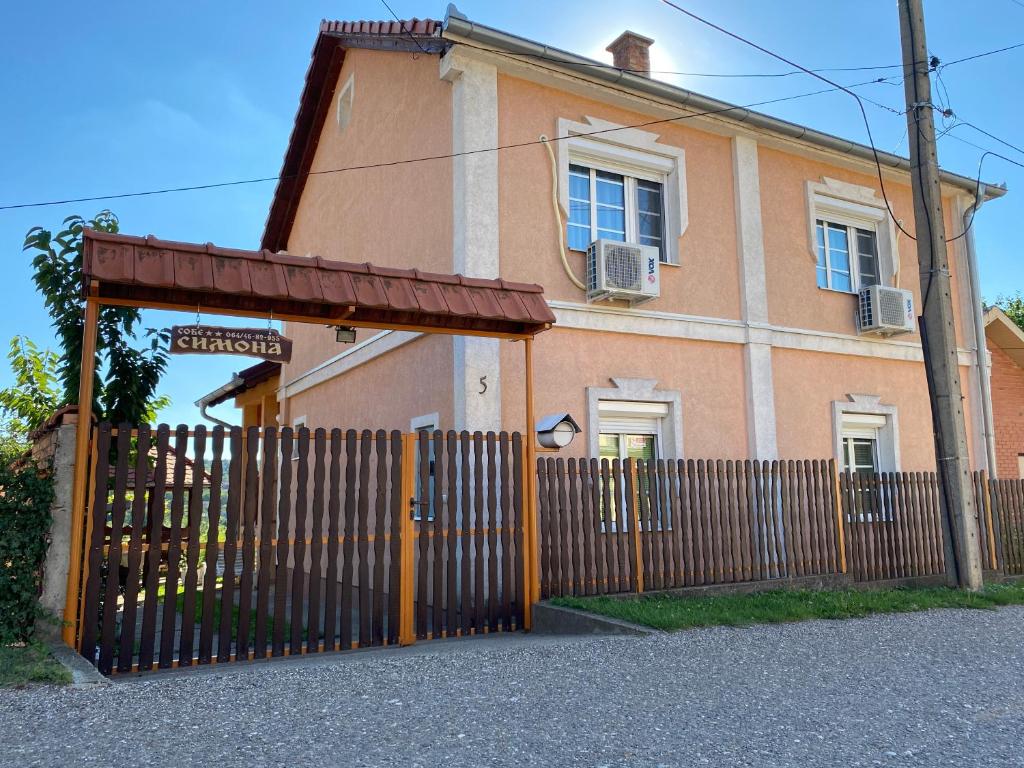 un cancello di fronte a una casa con una recinzione di Apartman Simona a Vrdnik