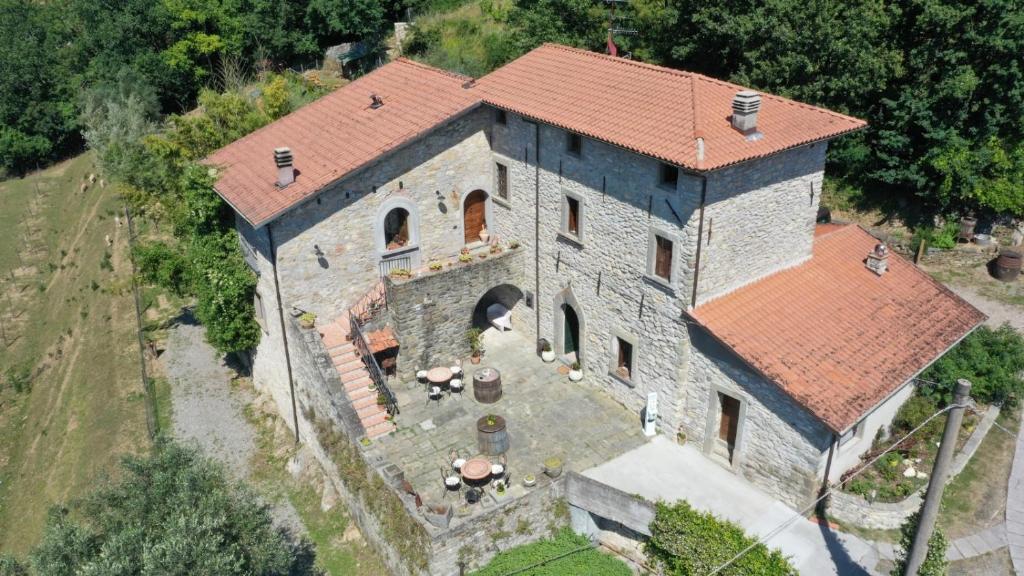 una vista aérea de una gran casa de piedra con techo rojo en Agriturismo Il Macereto, en Fivizzano