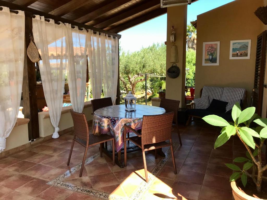 a dining room with a table and chairs on a patio at Holiday Home Baia Cofano in Custonaci