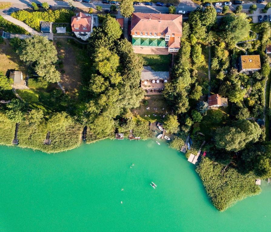 einem Luftblick auf ein Haus und einen See in der Unterkunft Strandhotel Vier Jahreszeiten Buckow in Buckow