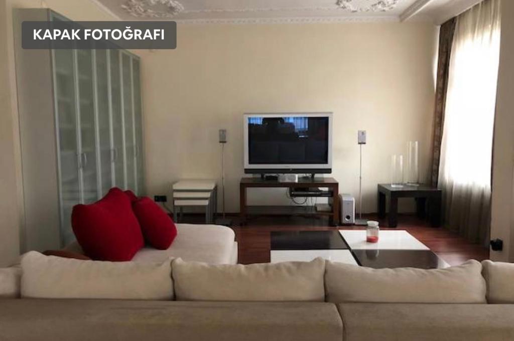 ein Wohnzimmer mit einem Sofa und einem Flachbild-TV in der Unterkunft Main Street Resort in Istanbul