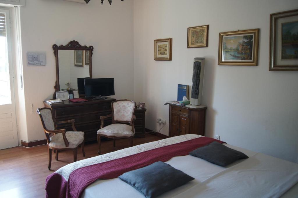 B&B Maddalena Di San Zeno في فيرونا: غرفة نوم بسرير ومكتب ومرآة