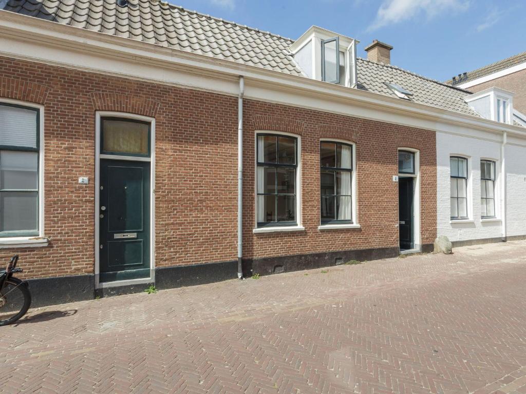 a red brick building with a black door on a street at Picturesque fisherman s house near the beach in Scheveningen