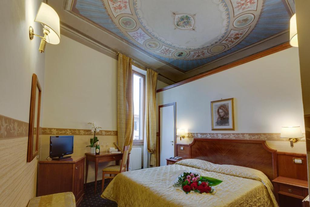 una habitación de hotel con una cama con flores. en Hotel Arizona, en Florencia