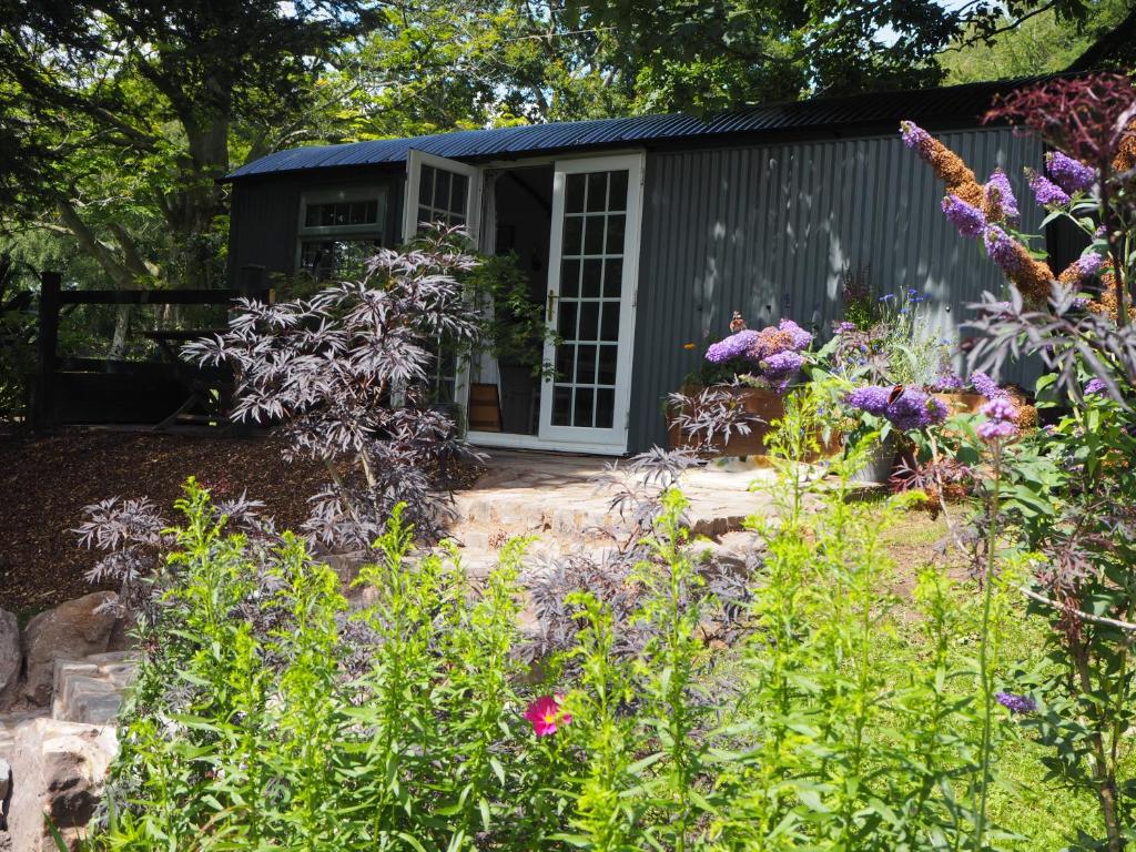 a garden in front of a shed with flowers at The Owl Hoot in Ipstones