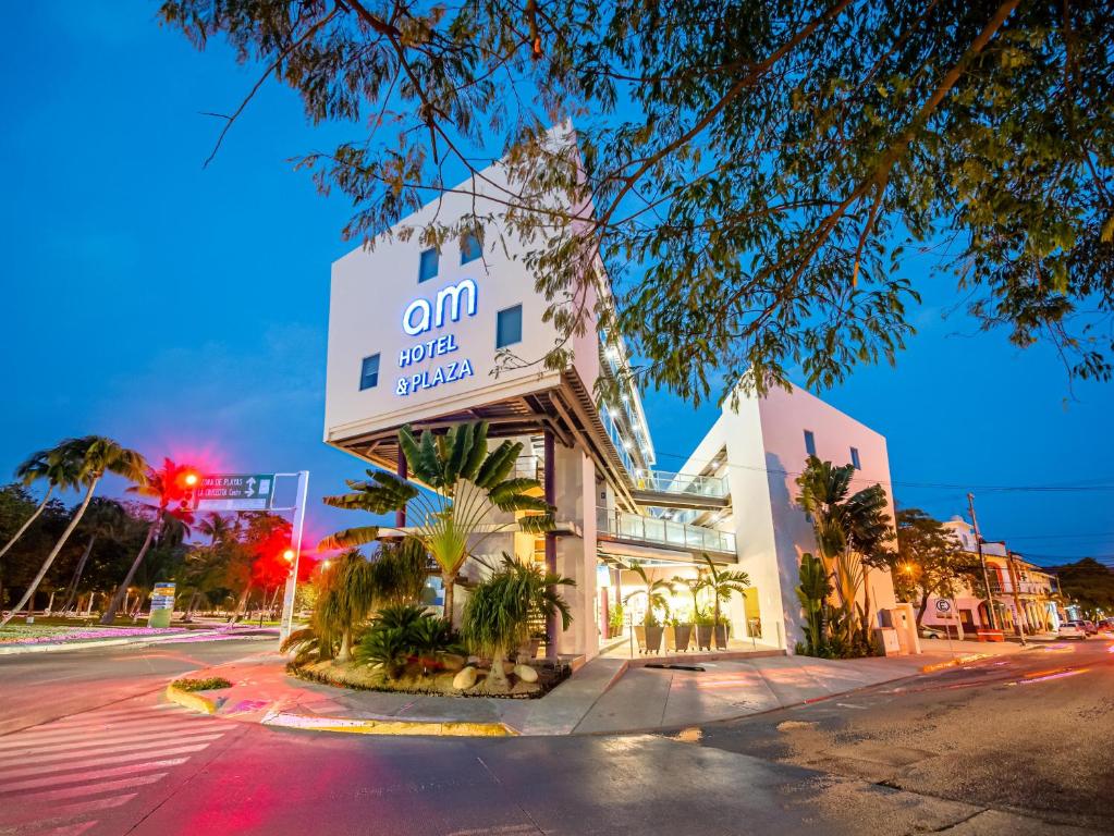 un bâtiment au coin d'une rue la nuit dans l'établissement AM Hotel y Plaza, à Santa Cruz Huatulco