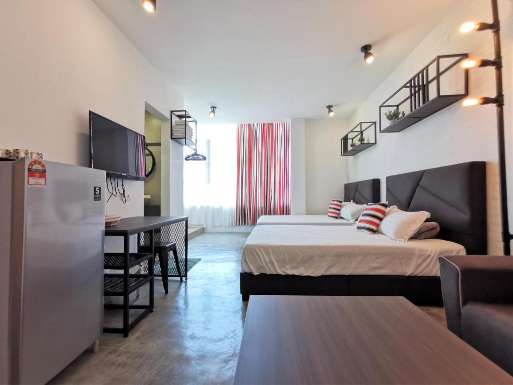 a hotel room with two beds and a desk at MWV Suite Room (MUAR) in Muar