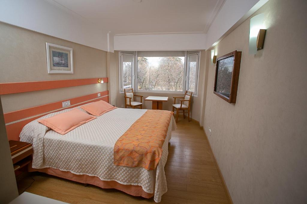 1 dormitorio con cama, mesa y ventana en Hotel Dior en Tandil