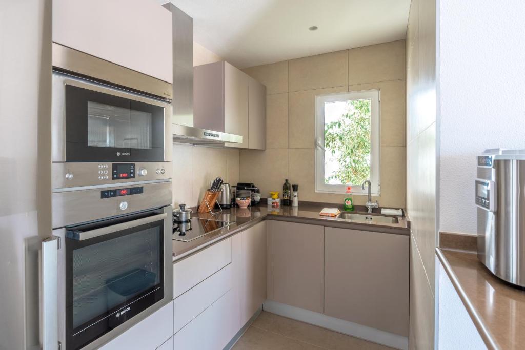 a large kitchen with stainless steel appliances and a window at Maryvilla Inspiración y Vacaciones - Bungalows in Calpe