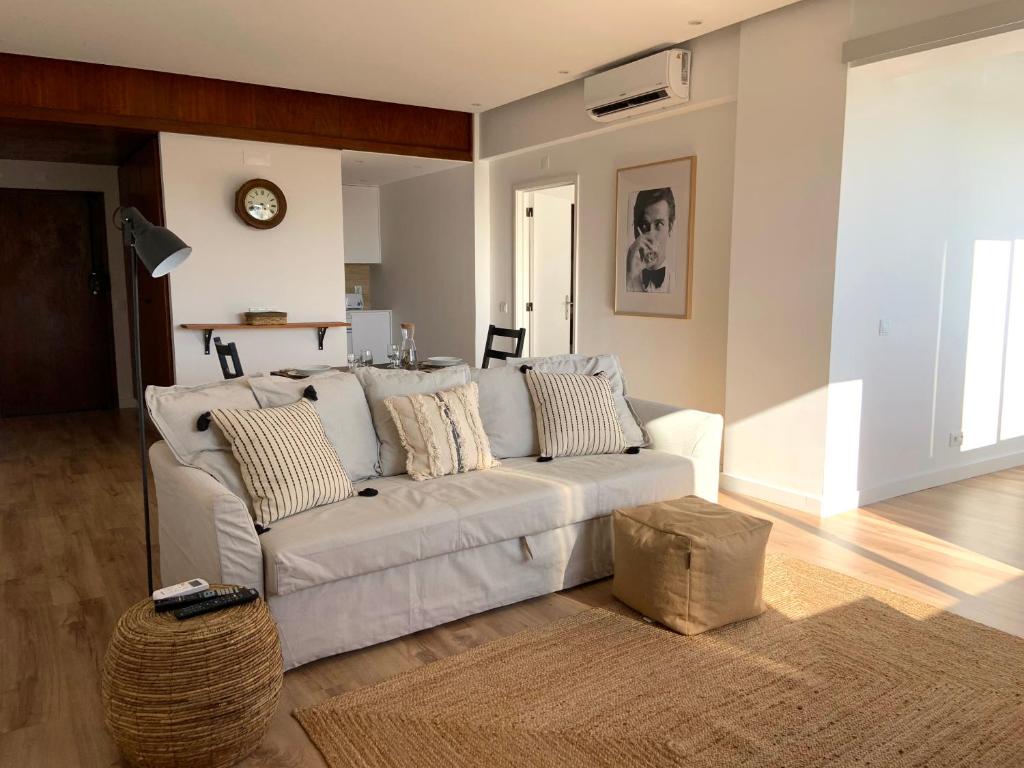 ein Wohnzimmer mit einem weißen Sofa und einem Tisch in der Unterkunft Pine Apartment - a 3m da ciclovia Guincho in Cascais