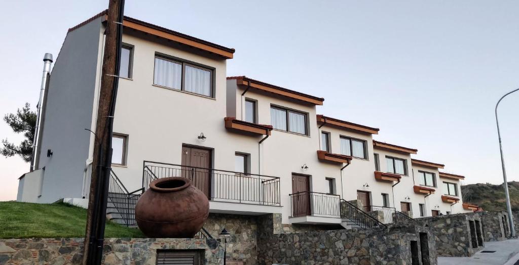 un bâtiment avec un grand vase devant lui dans l'établissement Melissonas Villas, à Phini