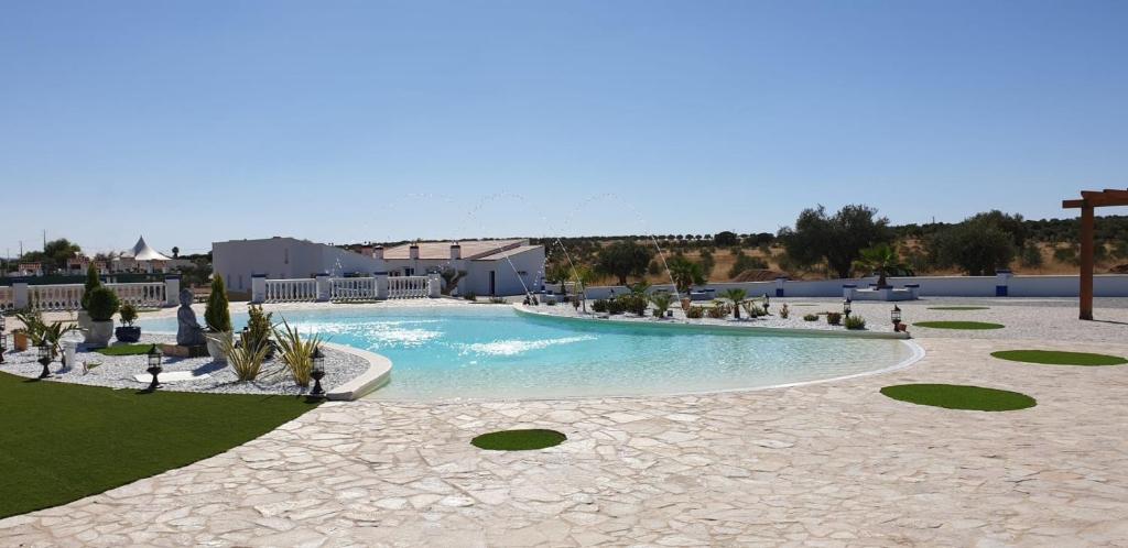 une grande piscine au milieu d'un complexe dans l'établissement Olívale - Turismo Rural, à Campo Maior