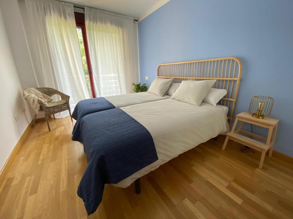 a bedroom with a large bed with a wooden floor at Apartamento LLAR DEL CARES in Arenas de Cabrales
