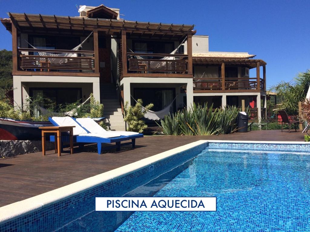 une villa avec une piscine en face d'une maison dans l'établissement Pousada Vivenda do Rosa, à Praia do Rosa