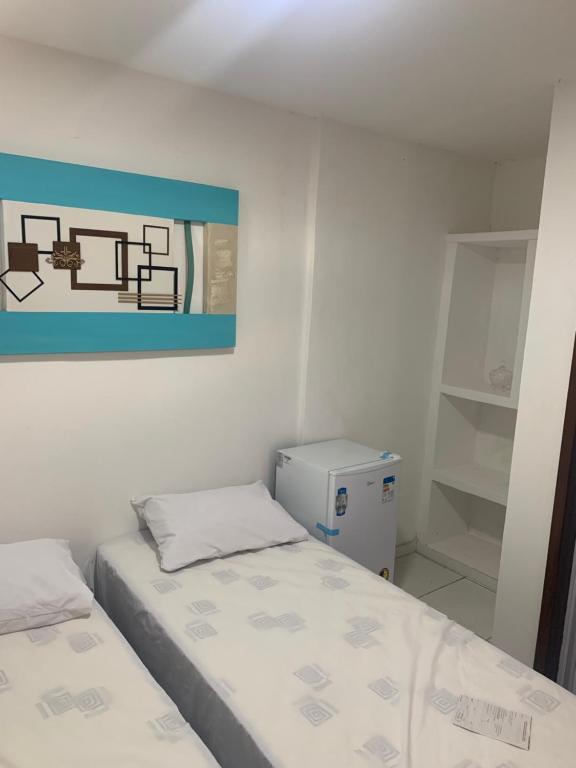 - une chambre avec 2 lits et un tableau mural dans l'établissement Zaca’s House, à Vila Velha