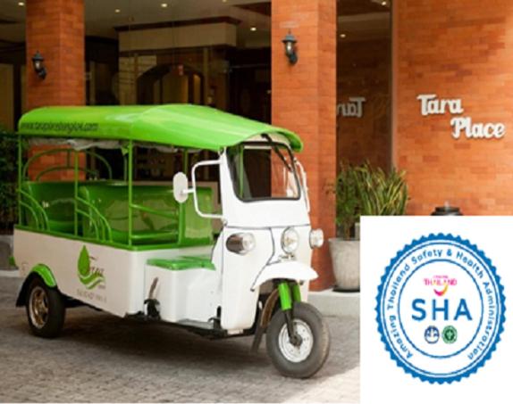 a small green and white golf cart parked in front of a building at Taraplace Hotel Bangkok in Bangkok