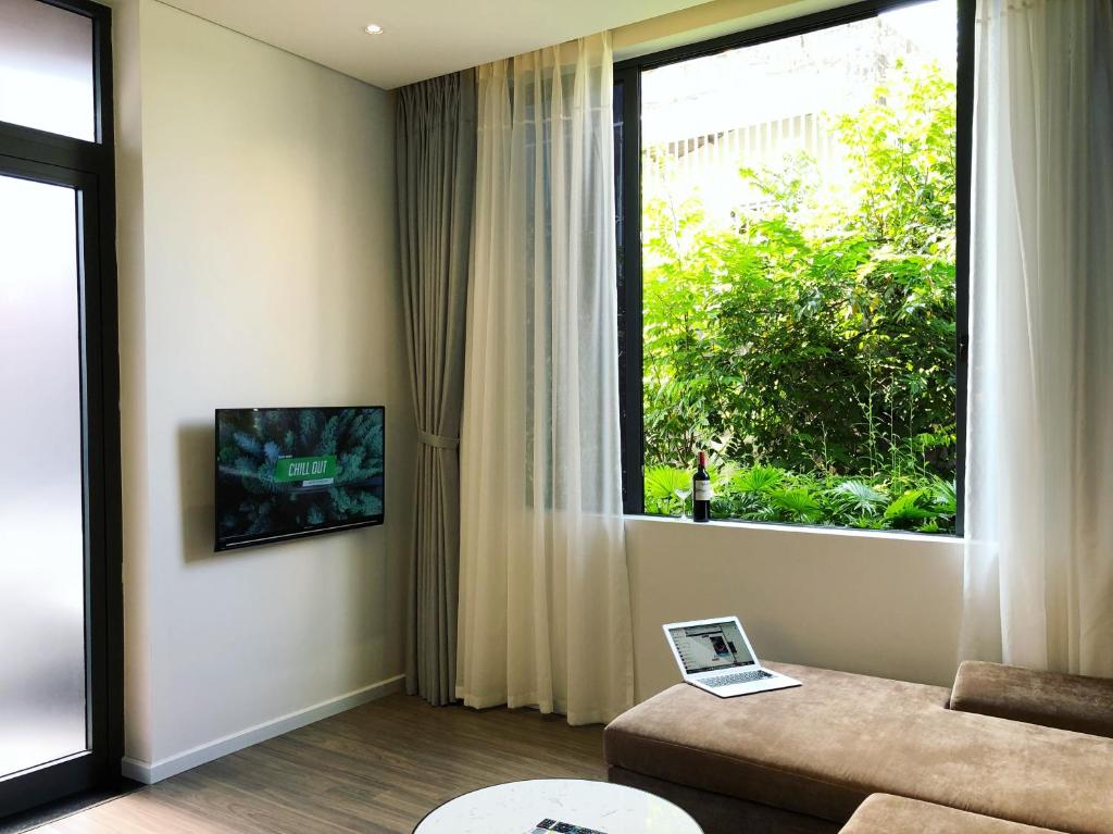 a living room with a couch and a large window at Khe Suites Le Lai Apartment - Self Check-in with Lockbox in Da Nang