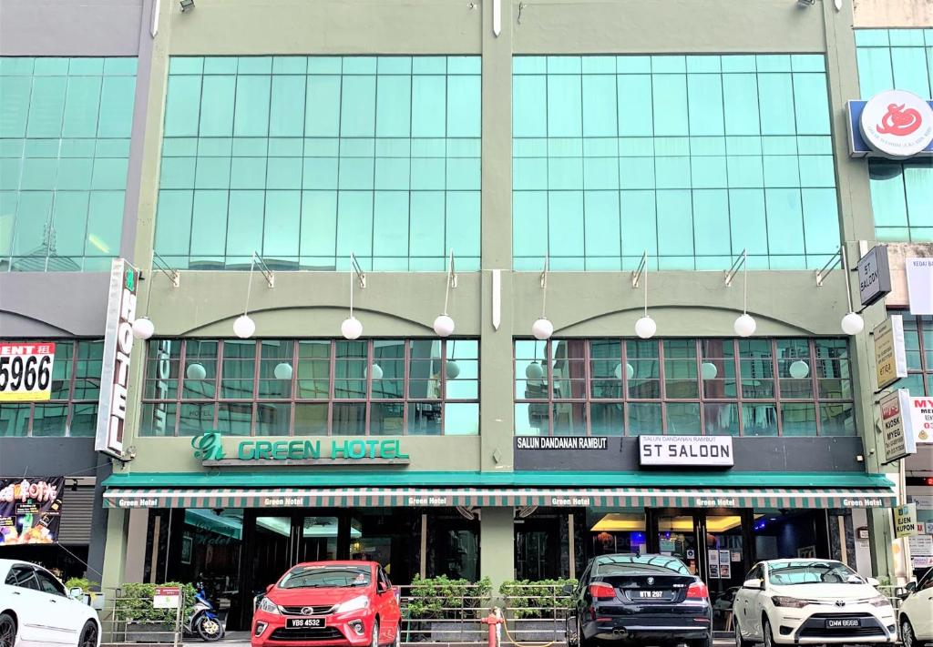 a large building with cars parked in front of it at Green Hotel in Puchong
