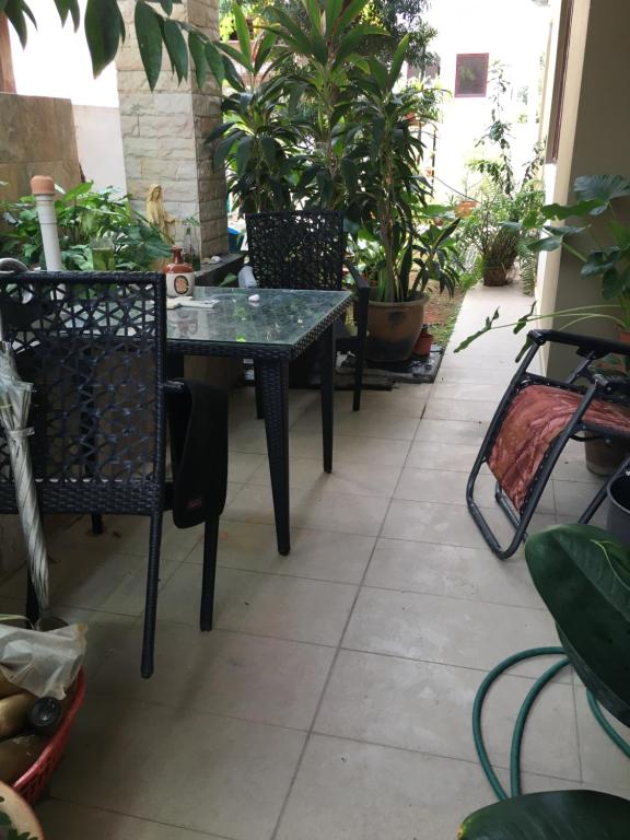 a table and chairs in a patio with plants at BM Rooms in Bukit Mertajam