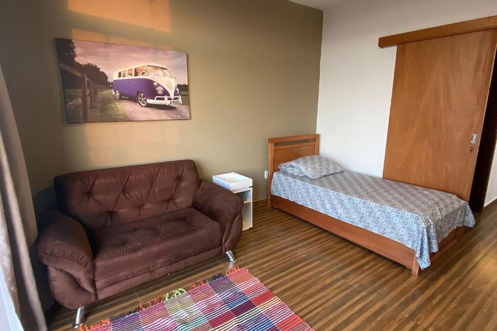 Habitación pequeña con cama, sofá y cama en Apartamento novo, completo e bem localizado., en Pirassununga