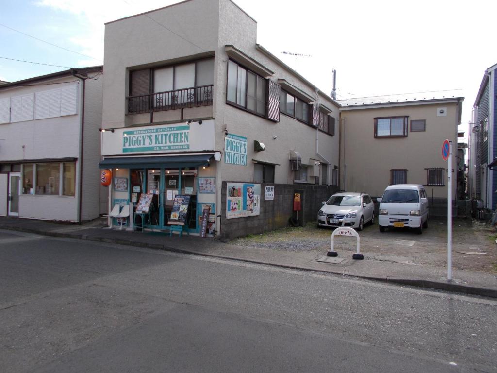 um edifício com dois carros estacionados num parque de estacionamento em Akitaya Annex em Kamakura