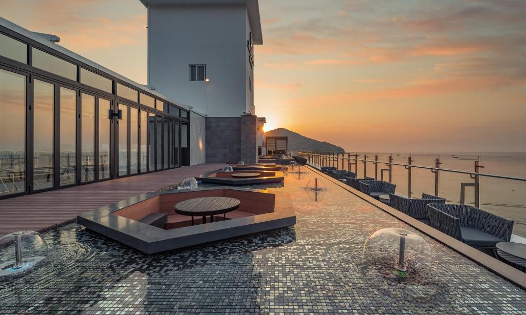a building with a table on a balcony with the sunset at Stubborn Hotel in Geoje